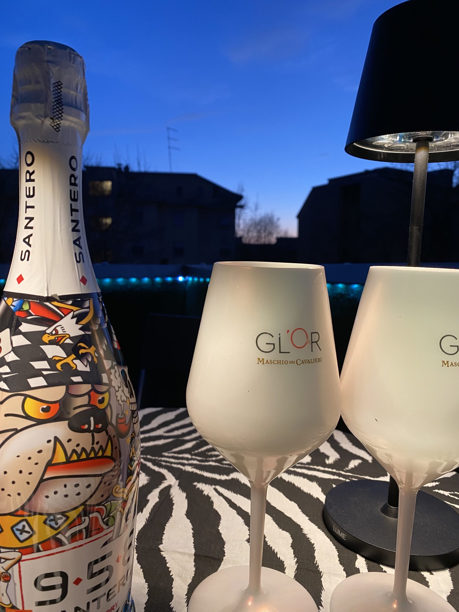 Dettaglio della terrazza privata con tavolino, prosecco e calici al tramonto nel B&B G-House a Parma.